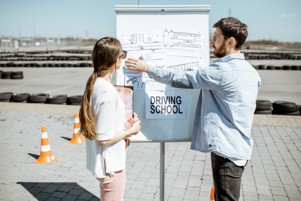 Instructor explaining traffic signs to a female learner outdoors