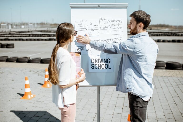 Instructor explaining traffic signs to a female learner outdoors